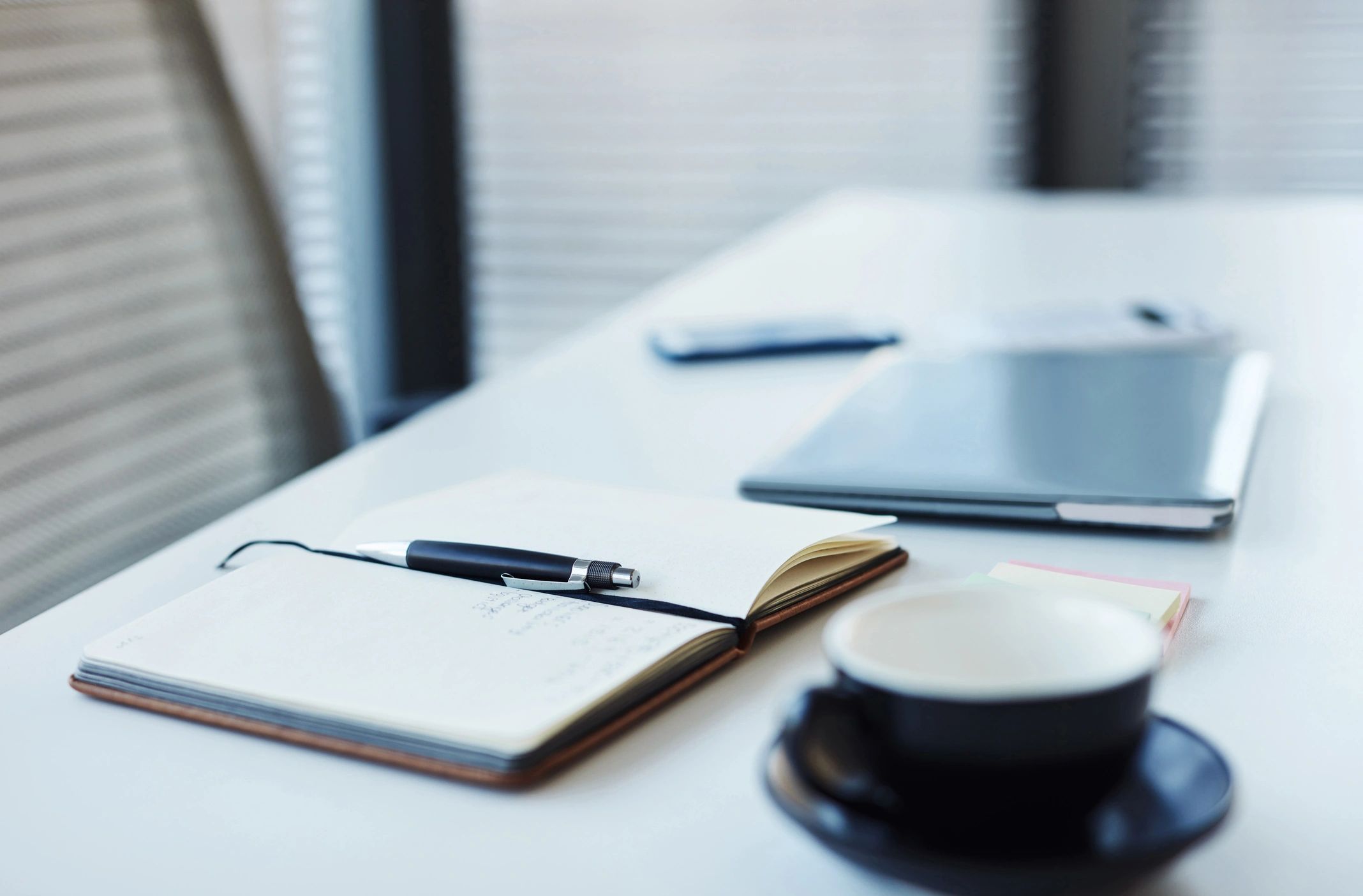 Laptop and notebook on a desk for bookkeeping and planning