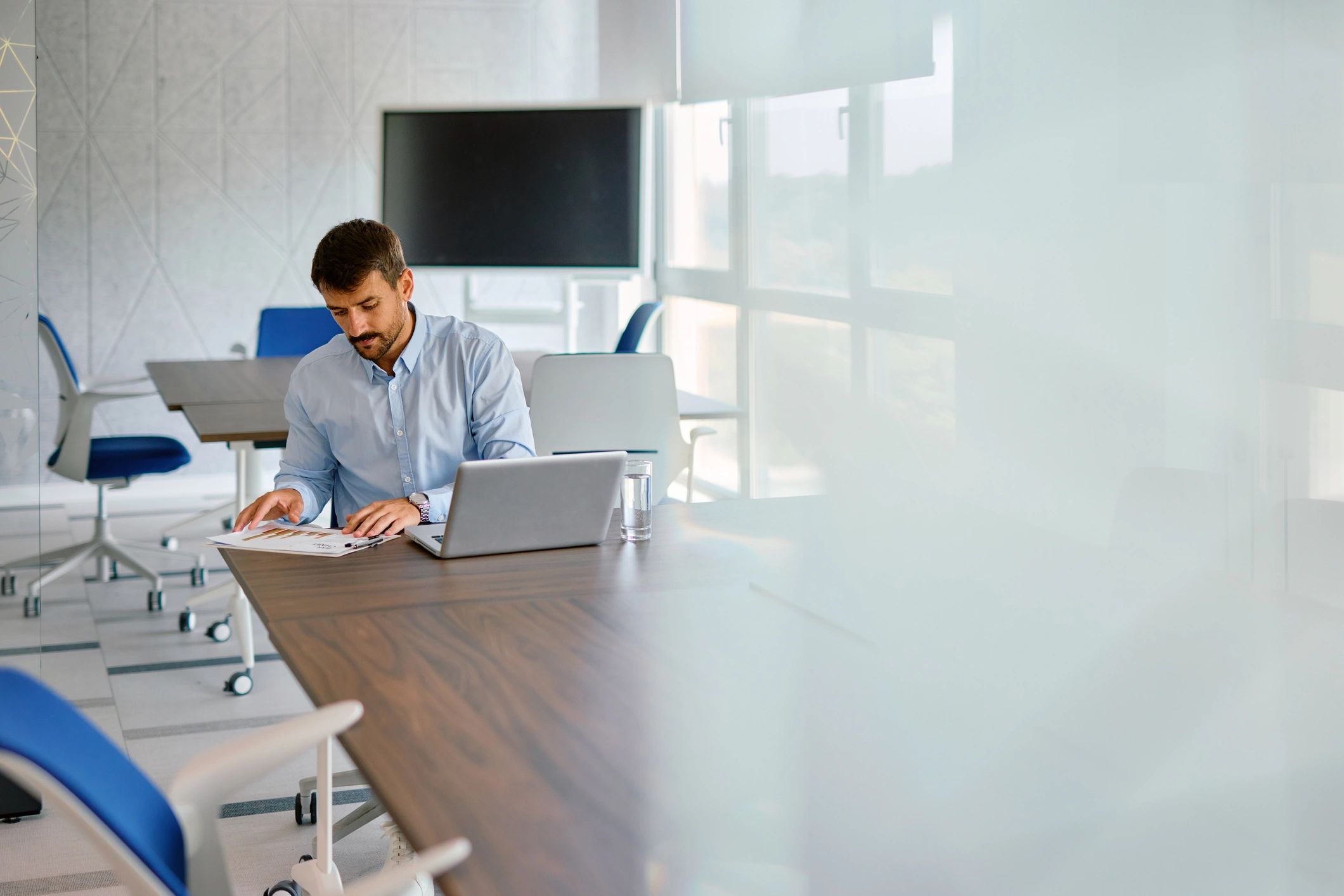 Professional reviewing financial reports on a laptop in an office